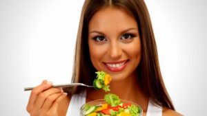 woman with long shiny hair eating salad