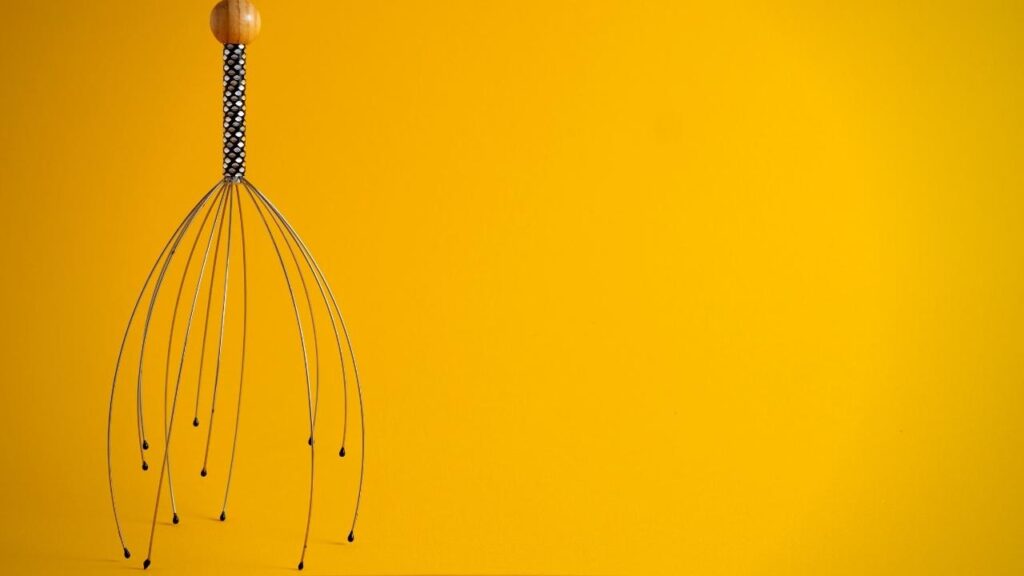 scalp massager with yellow background