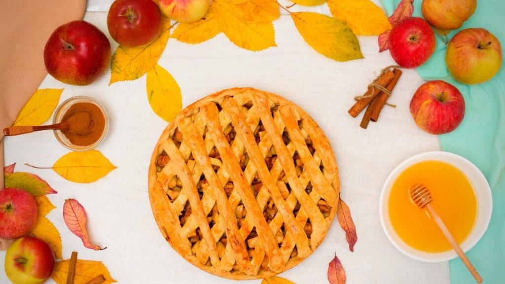 apple lattice pie circled by leaves and apples