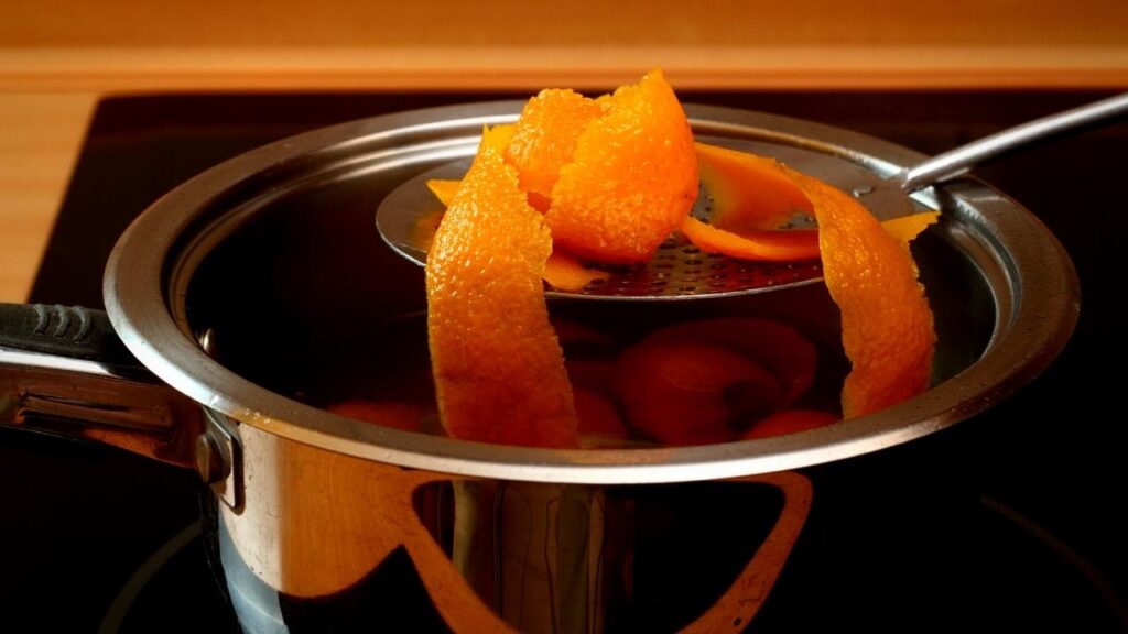 spoon of orange peel above simmer pot