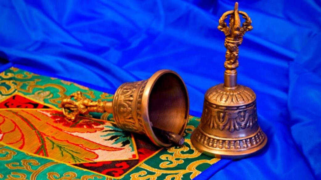 two tibetan bells on a blue cloth