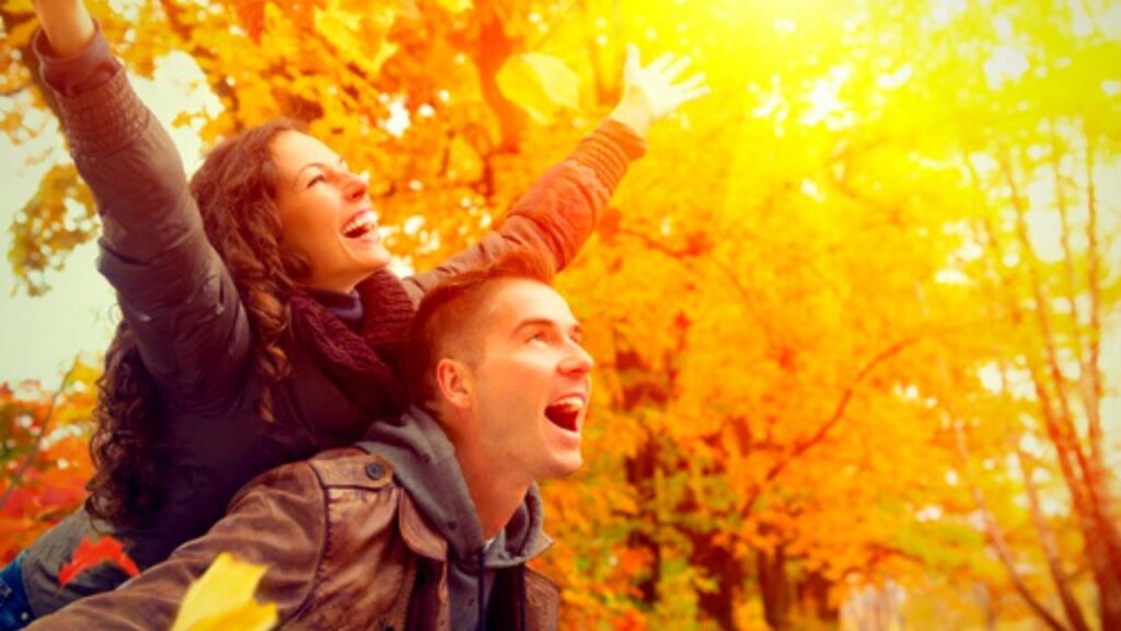 happy young couple enjoying the yellow autumn colours