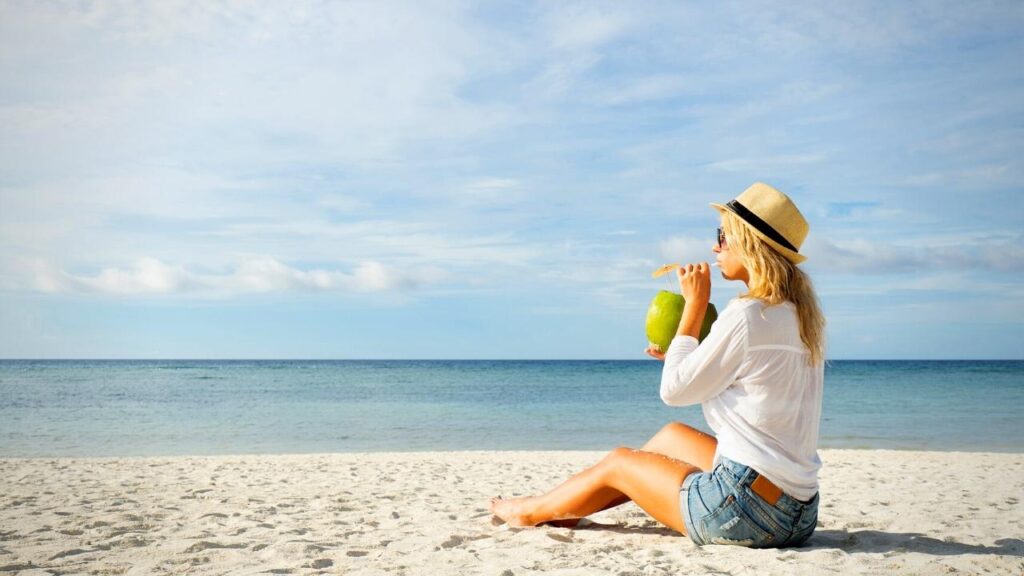 woman sitting on beach enjoying summer sun