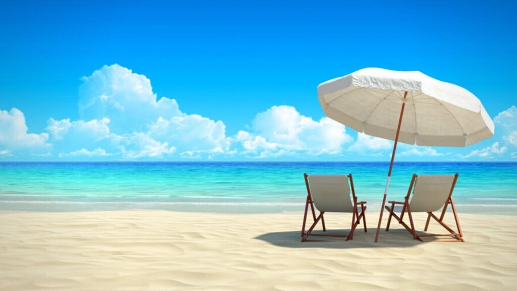 parasol and 2 deckchairs on sunny beach
