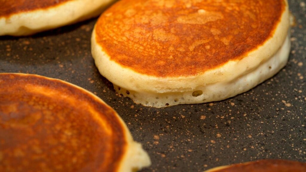 thick pancakes cooking on griddle pan