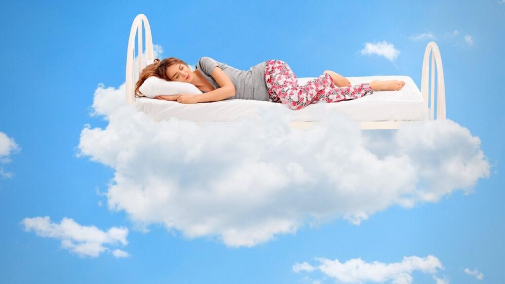 woman sleeping on a white bed in the clouds