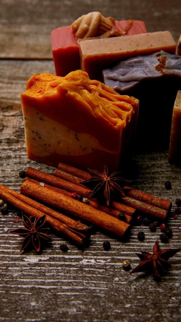 cinnamon soap bars with cinnamon sticks on wooden table