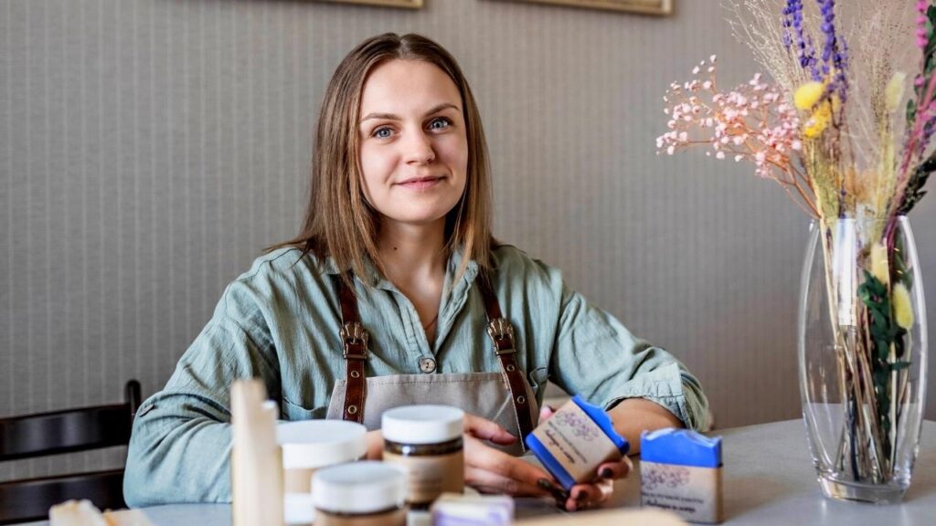 lady soap maker sitting with products on table