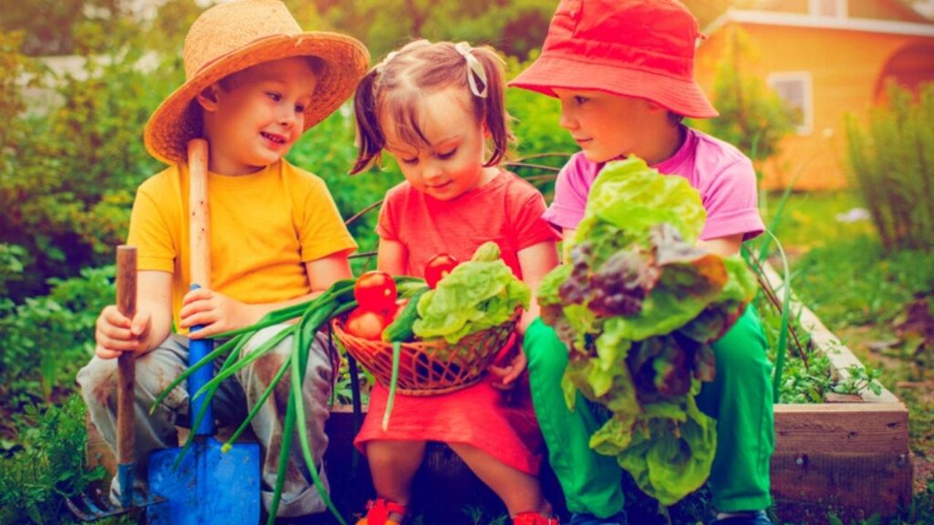 three children with home grown vegetables