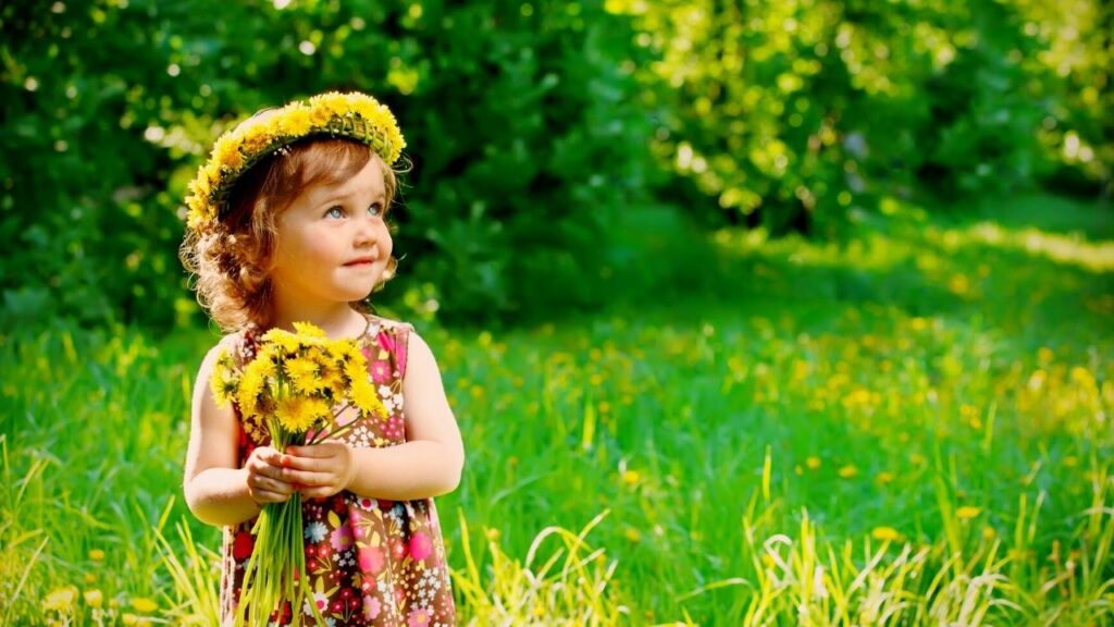 small girl with floral head wreath holding bunch of flowers