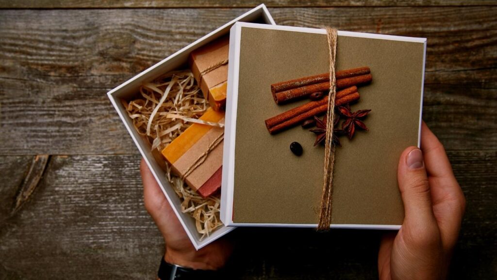 mans hands opening gift box of handmade soaps