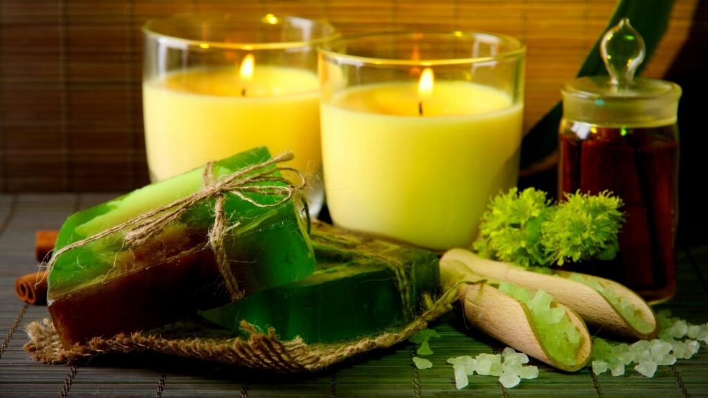 green handmade soap bars beside yellow candles