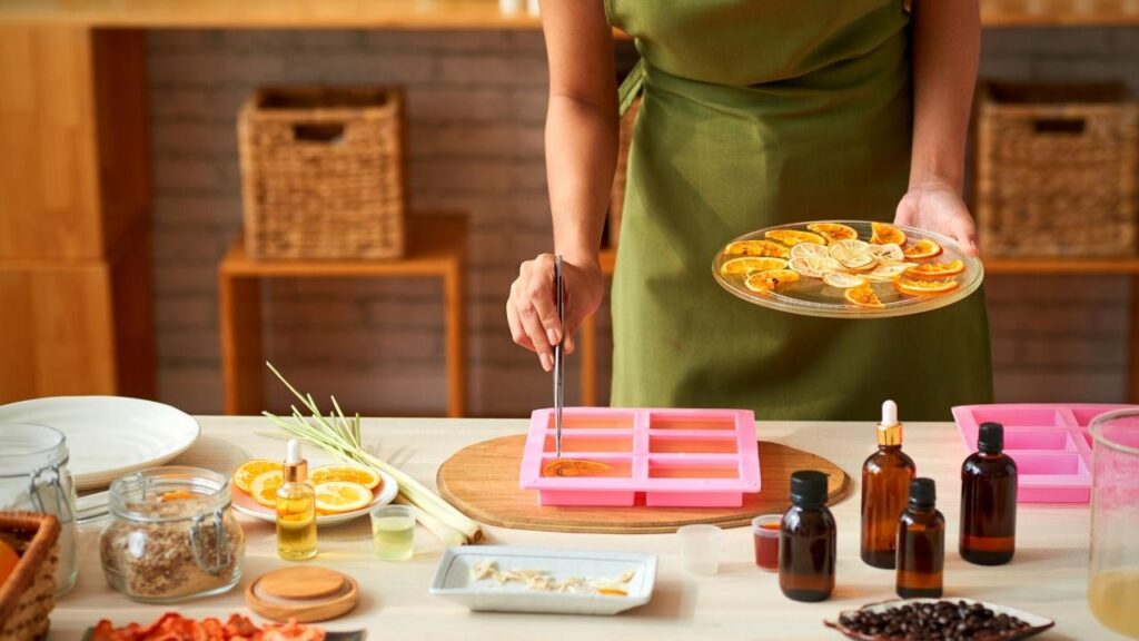 woman putting soap mixture into moulds on table