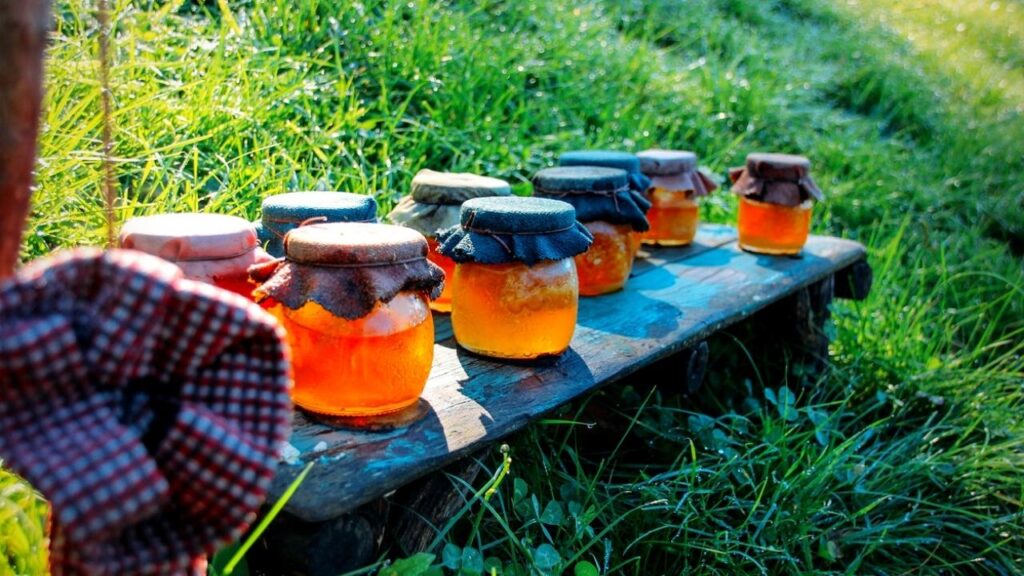 jars of honey on a table on the grass