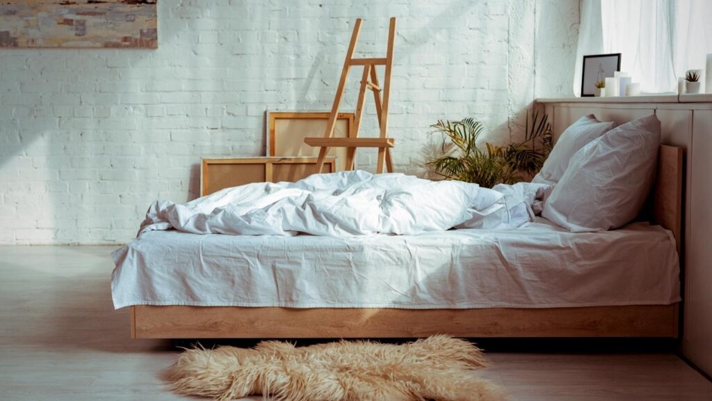 white Scandinavian bedroom design with rug beside bed