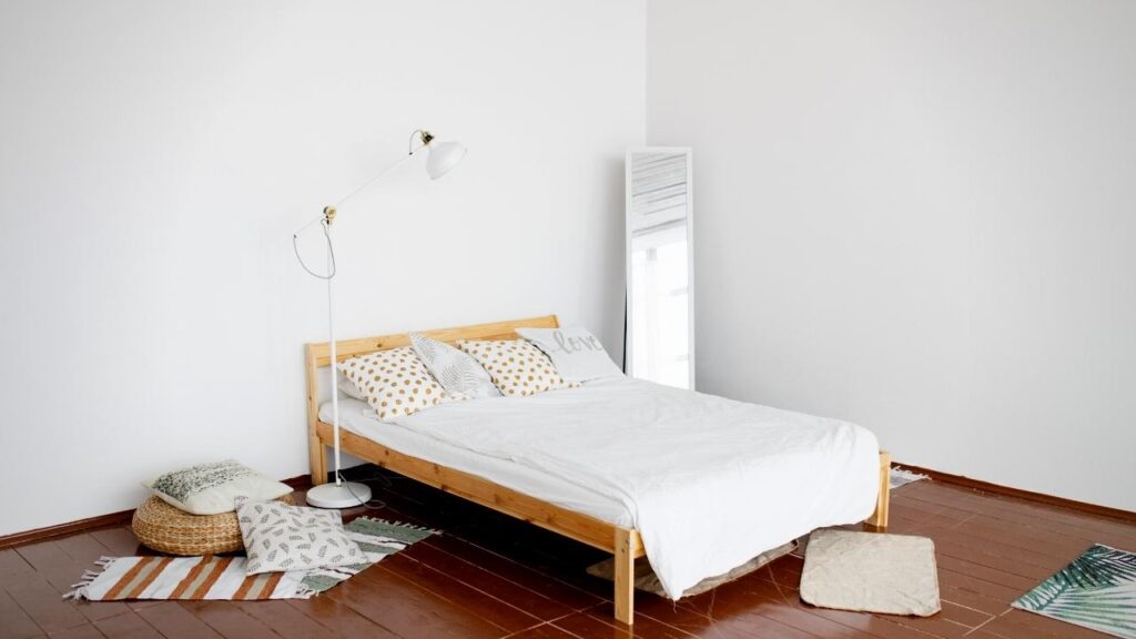 white walls, wooden floors and bed with white bedding 
