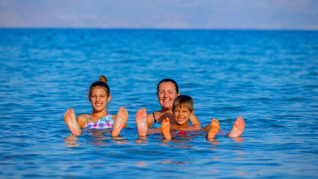 family of three floating on Dead Sea in Israel