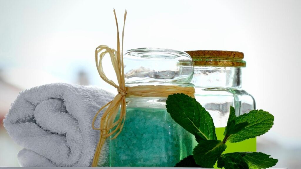 white towel, peppermint salts and leaves