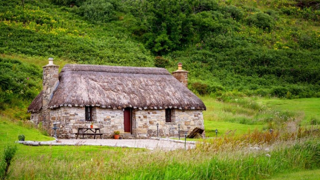 small stone cottage in green countryside