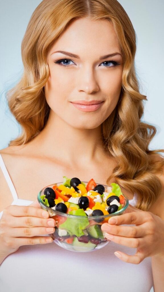 blonde haired woman holding bowl of salad