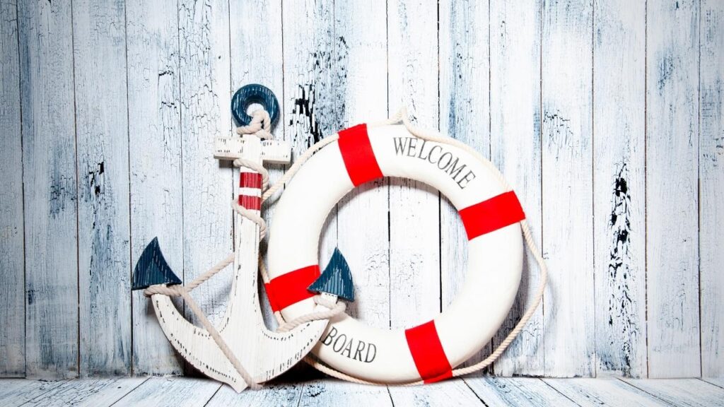 anchor and lifebuoy against white weathered board