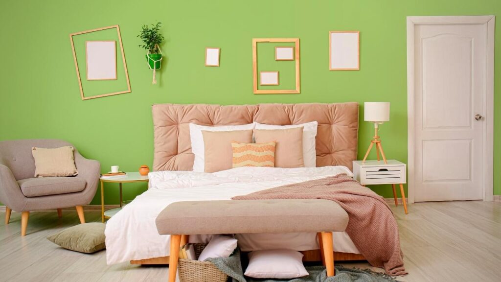 green bedroom wall behind neutral coloured bed