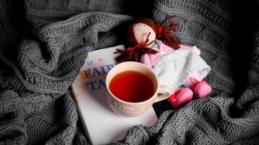 rooibos tea in cup, book and ragdoll