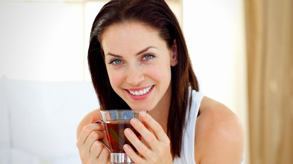 smiling woman drinking red bush tea