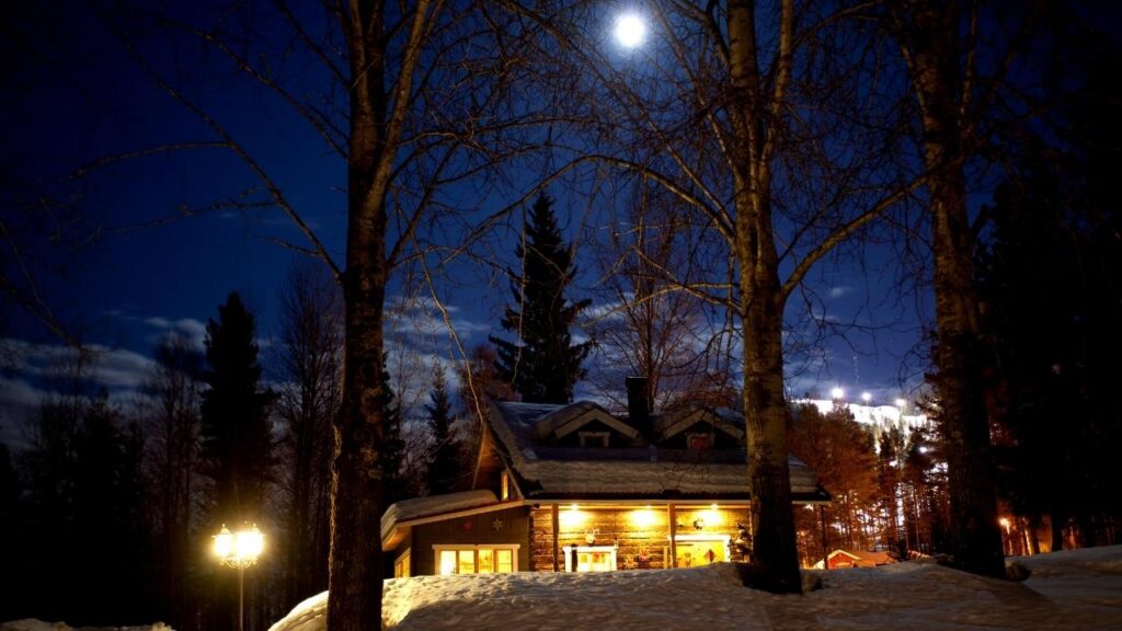 brightly lit cabin in snowy woodland