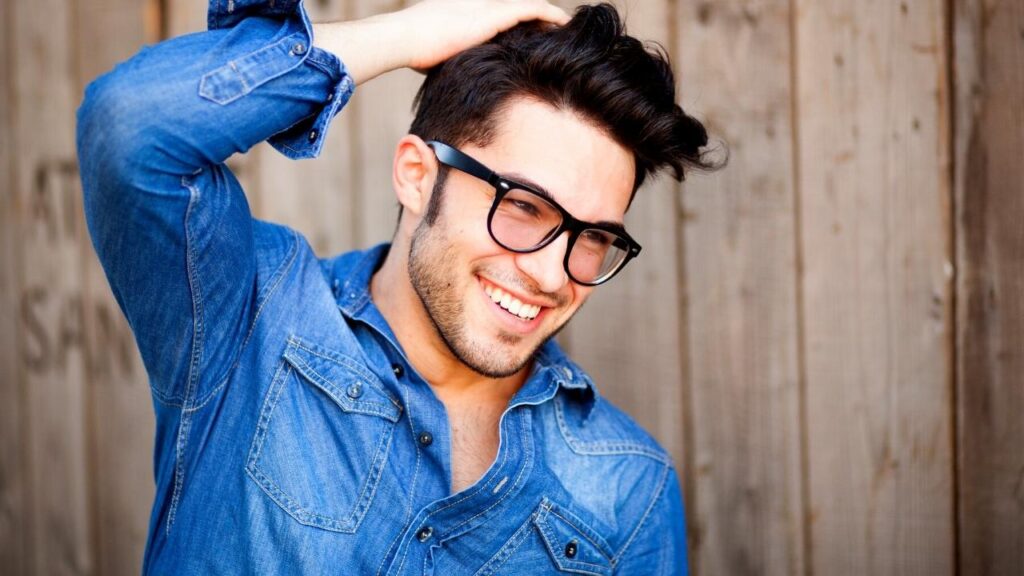 man with glasses patting hair