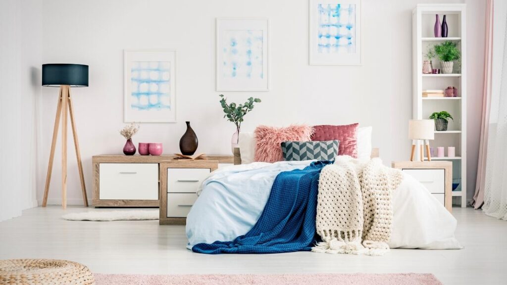 bed covered with blankets, throws and cushions