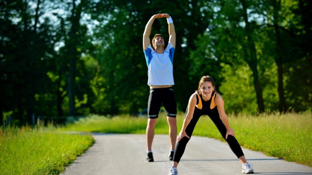 Young couple doing stretches in the park