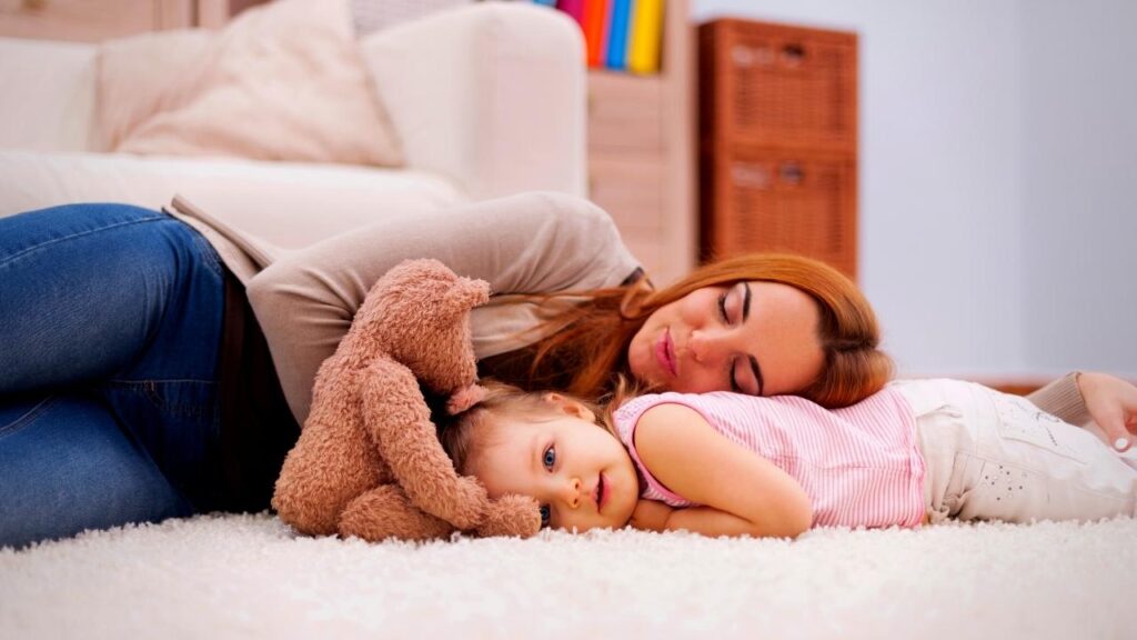 mother napping beside daughter with teddy bear