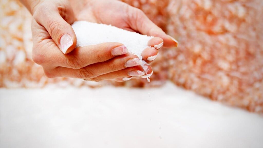 ladies hands full of epsom salts over bath