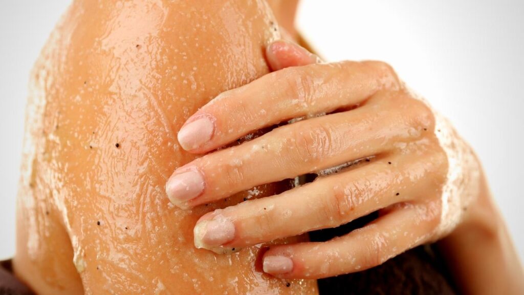 woman rubbing salt scrub onto arm