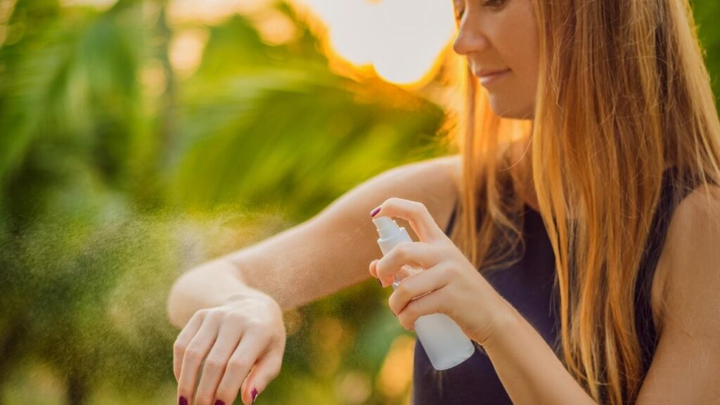 blonde woman spraying cooling mist on her arm