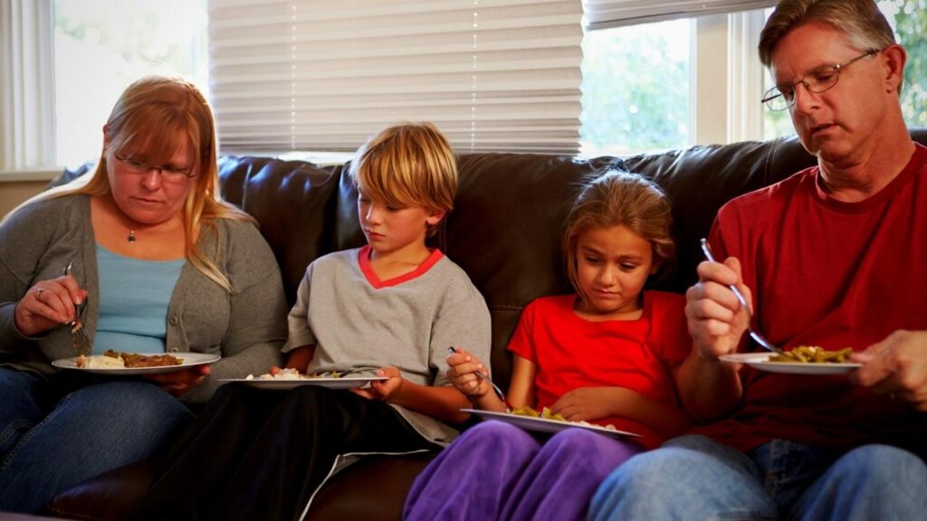 family of four on sofa eating unhealthy food