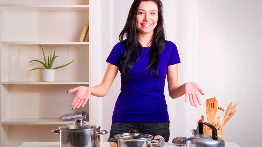 happy woman showing stainless steel cookware