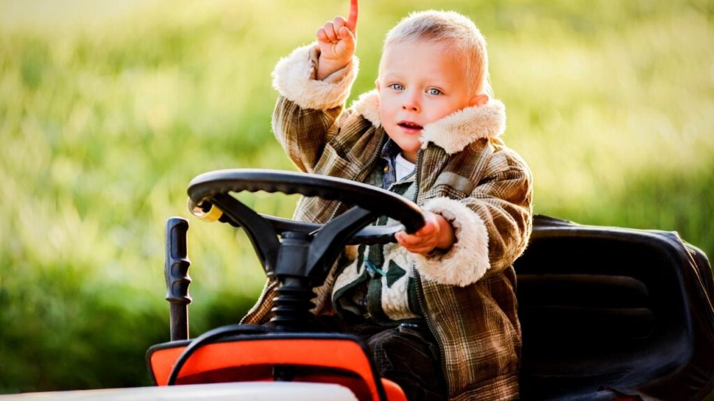 young blonde boy on sit on mower