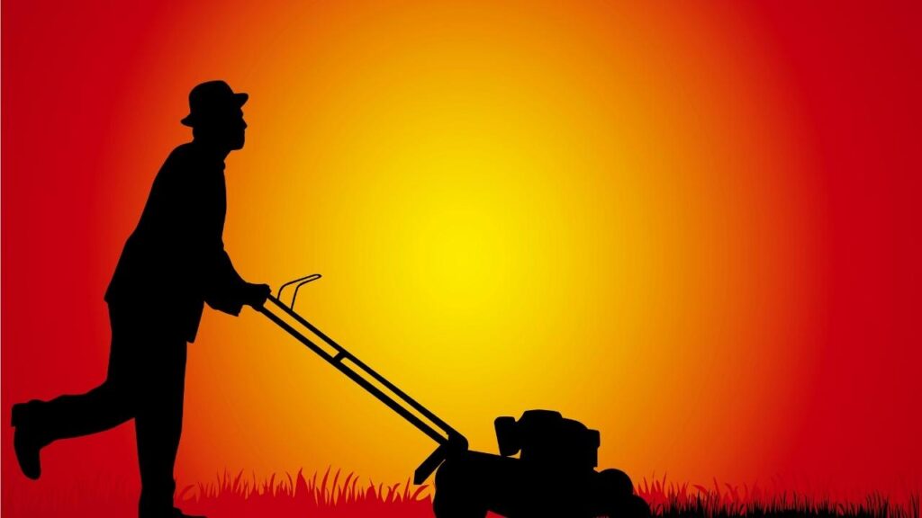 silhouette of man cutting grass