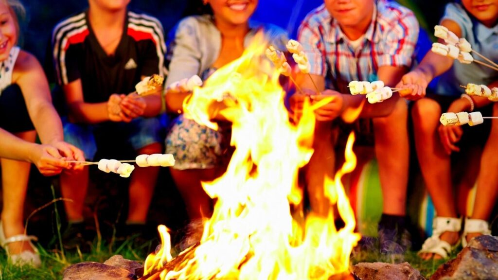 youngsters toasting marshmallows on bonfire