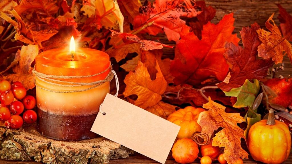 autumn candle beside leaves and berries
