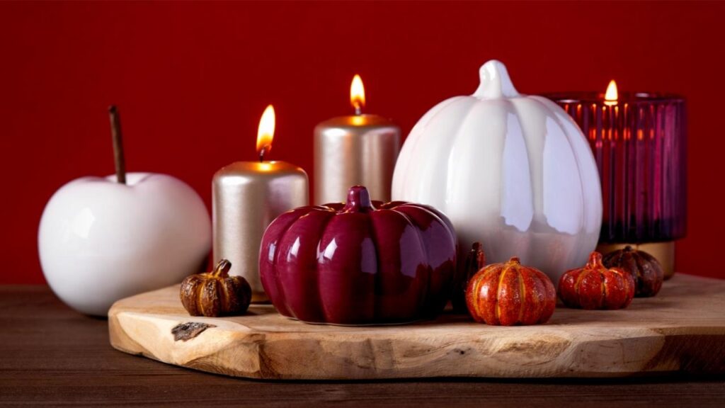 pumpkin shaped candles on wooden stand