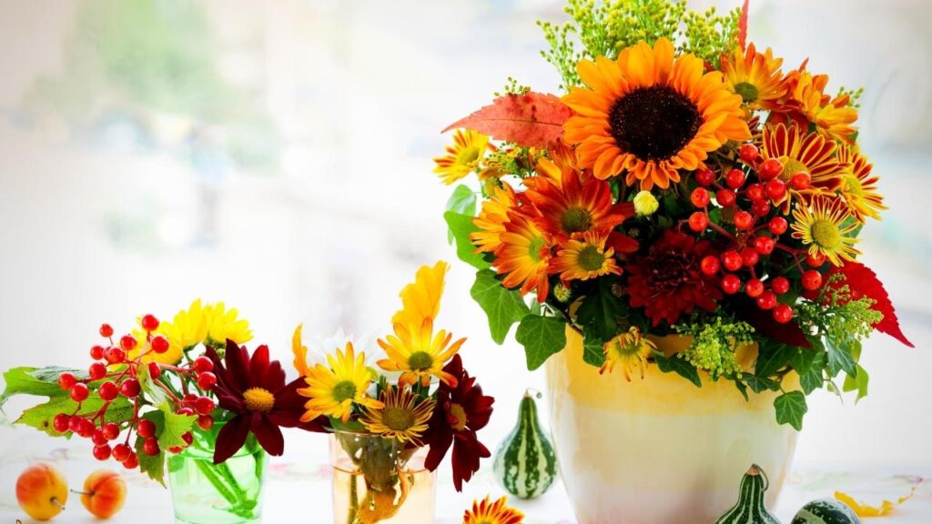row of autumn flowers in vases