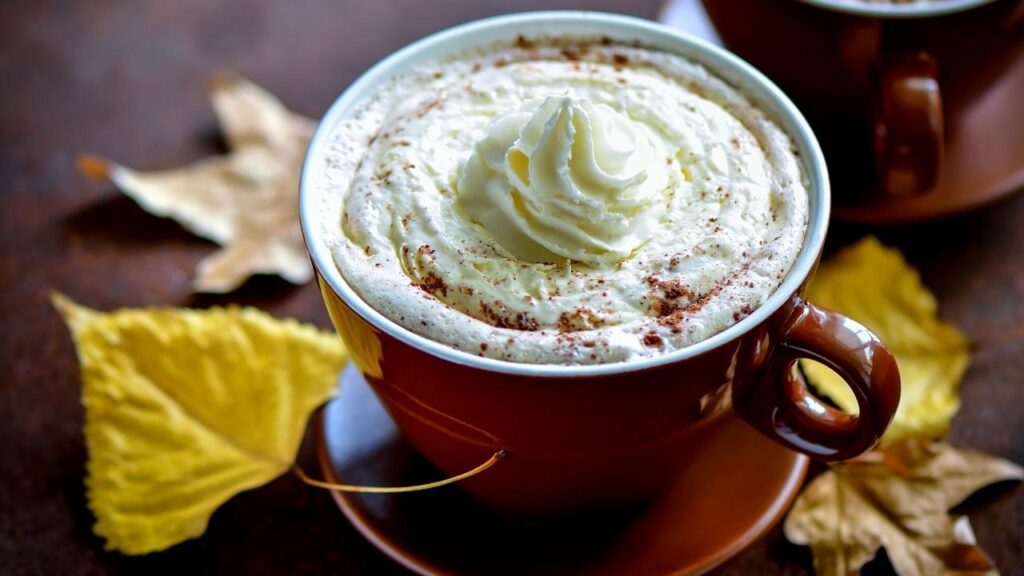 a cup of pumpkin latte with cream on top