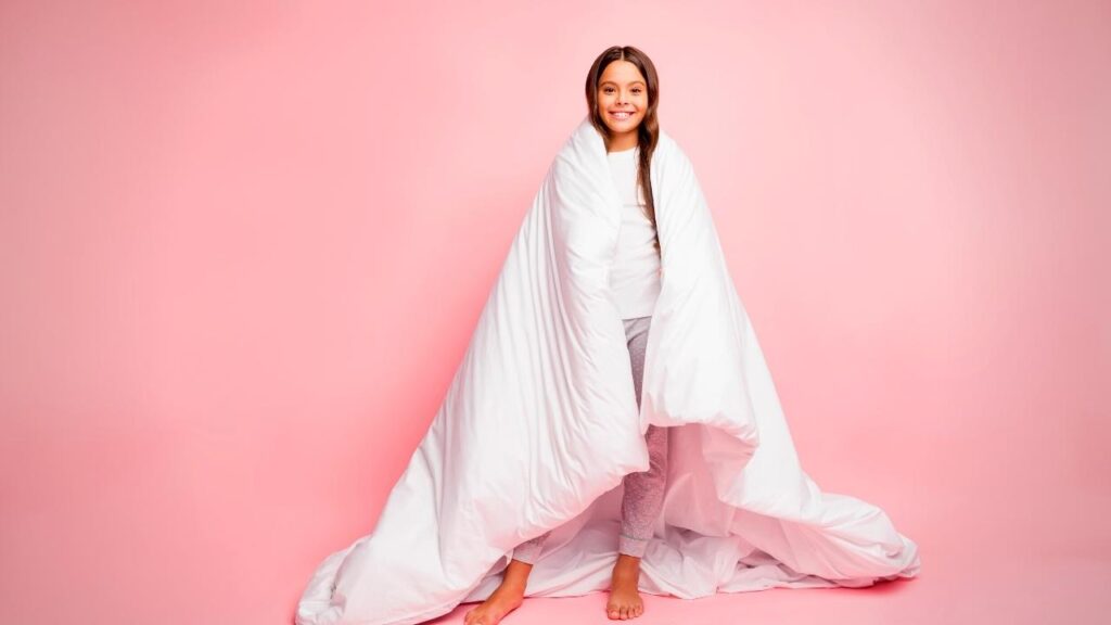 girl standing with duvet wrapped around her
