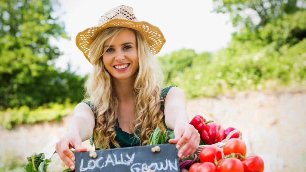 lady farmer holding locally grown sign