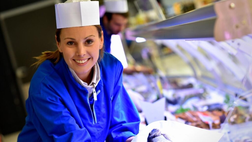 lady fishmonger beside fish display