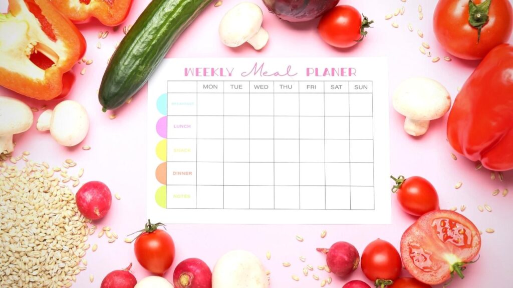 meal planner surrounded by veg