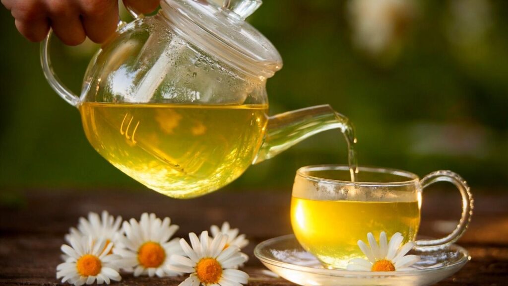 pouring tea into a glass cup